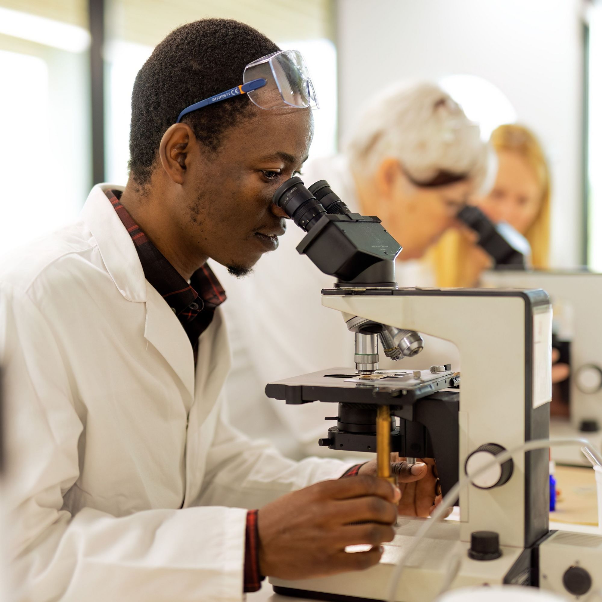 A student attending a short clinical course looks through a microscope