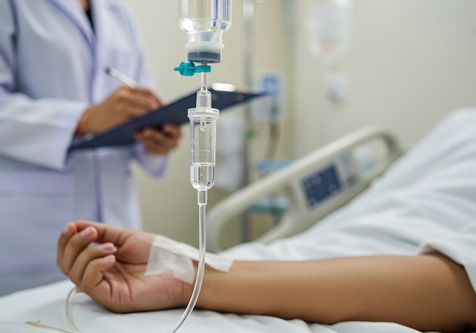 Patient in hospital bed receiving an infusion (Photo: AdobeStock)