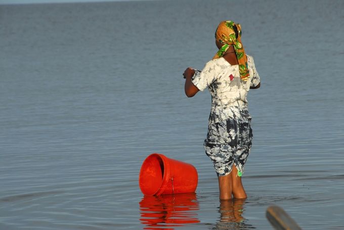 woman washing laundry in a lake (Photo: AdobeStock)