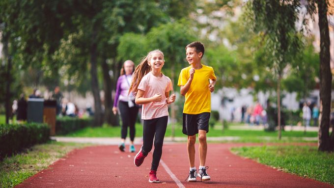 Child fitness, twins kids running on stadium track in city park , training and children sport healthy lifestyle. Outdoor activities by running make the child's body healthy and experience enriched