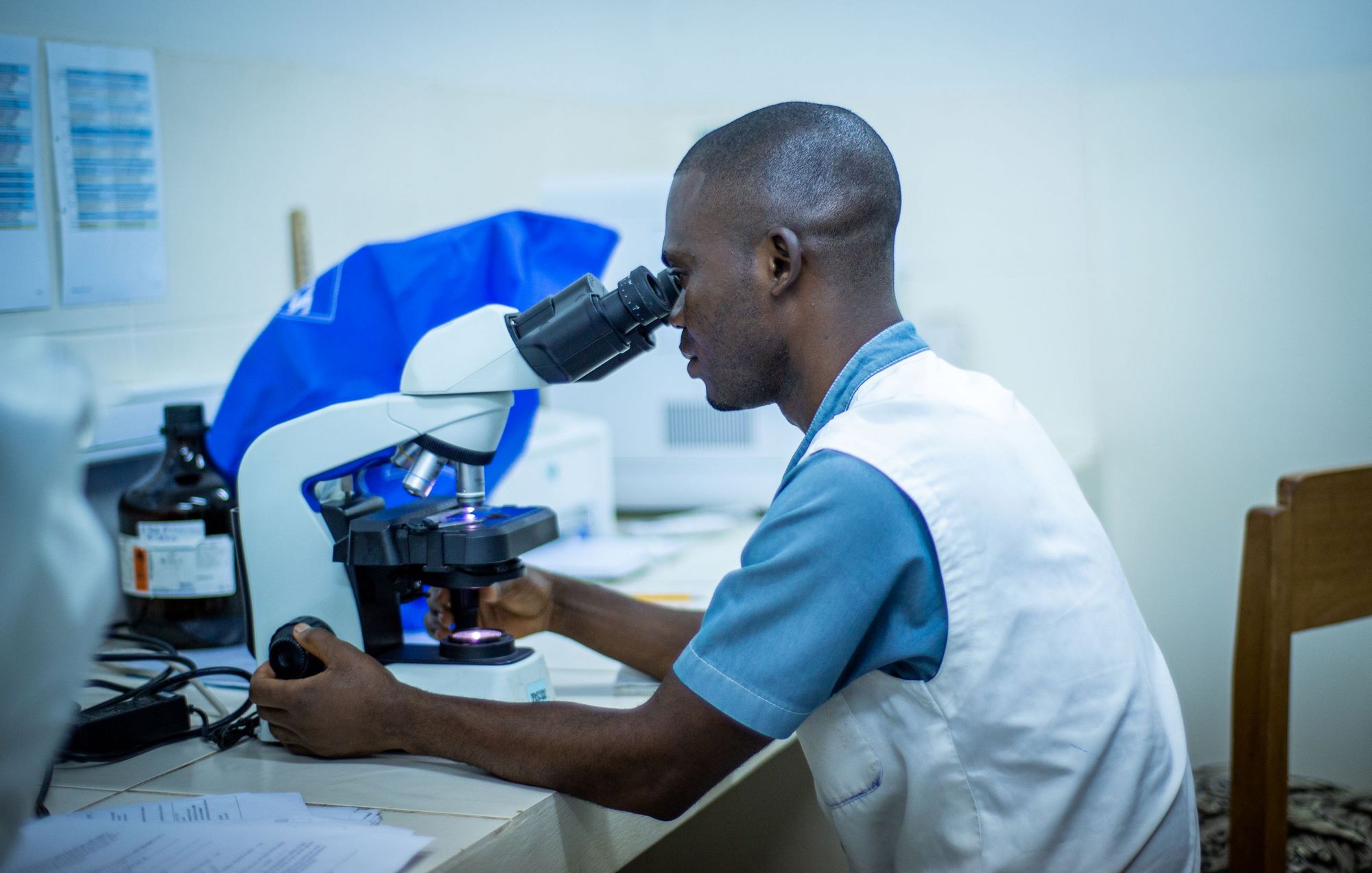 A laboratory technician examining samples under a microscope (Photo: Fairpicture/Swiss TPH)