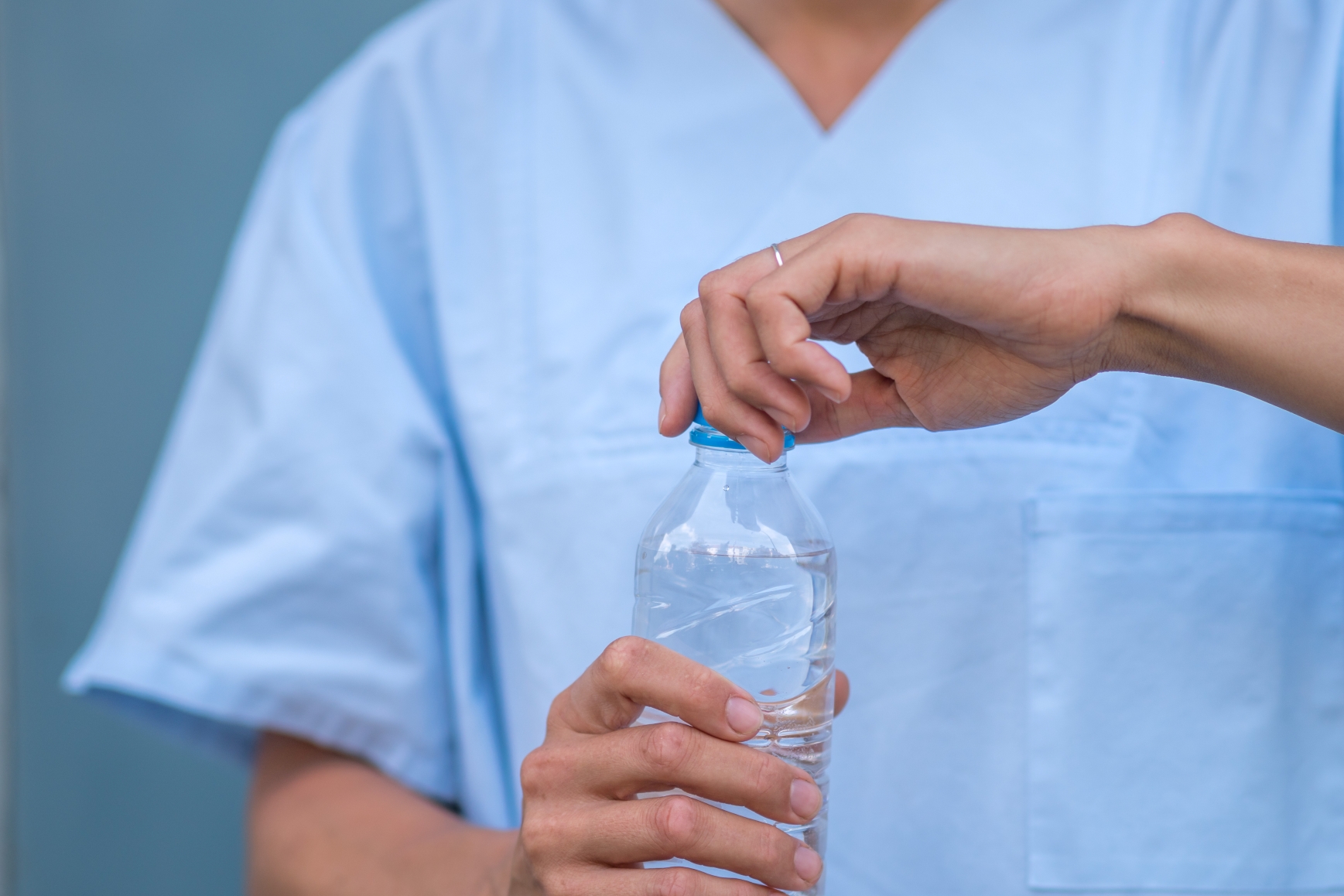 Medical staff opening a water bottle. Heat places significant strain on care staff (Photo: AdobeStock)