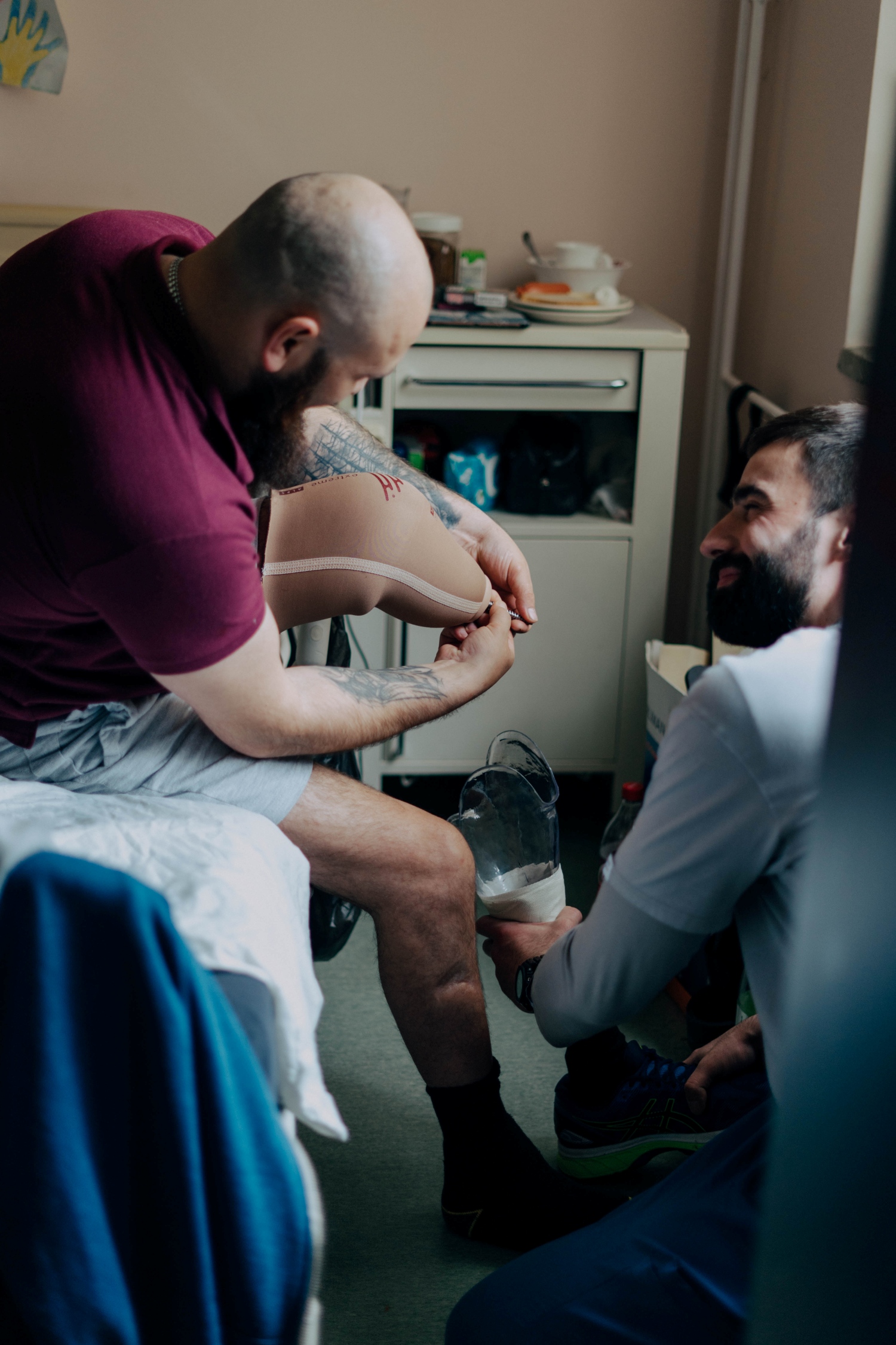 A healthcare worker helps a patient put on their prosthesis (Photo: Patients of Ukraine)